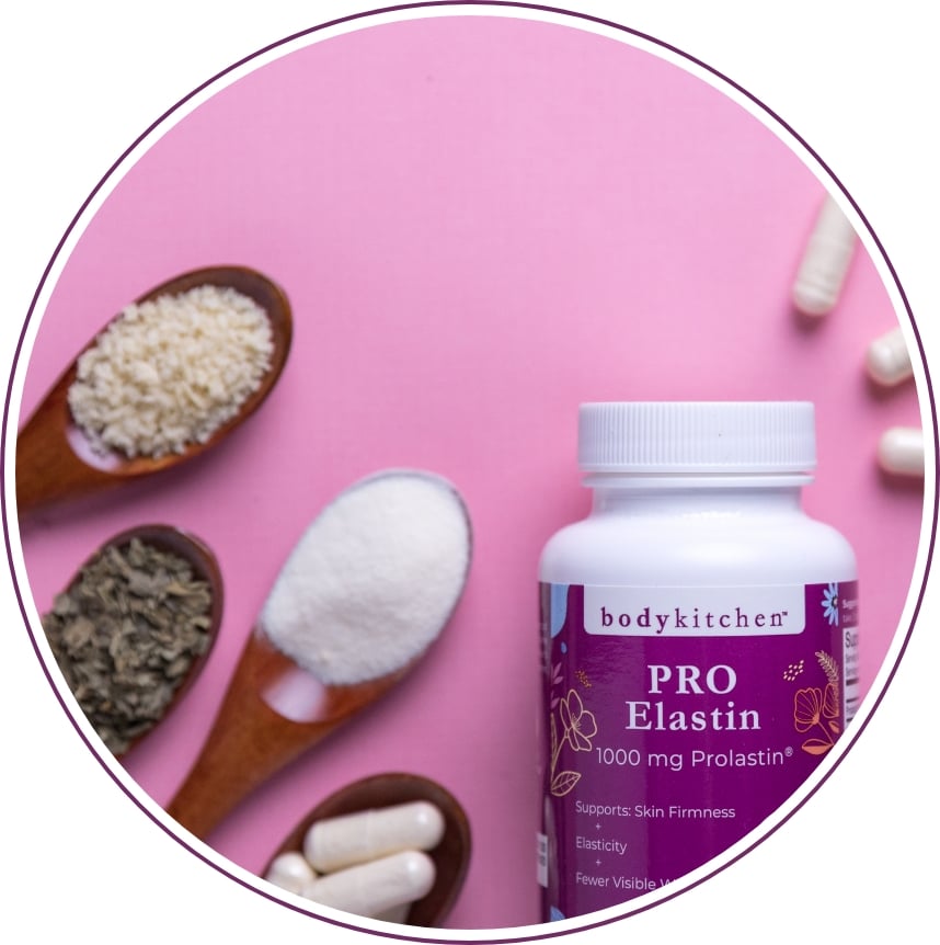 Bottle of Body Kitchen Pro-Elastin beside spoons of raw ingredients and capsules