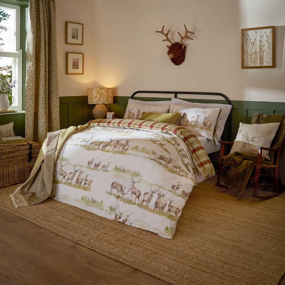 A duvet cover set featuring stags in a wild British landscape on one side and a tartan on the other