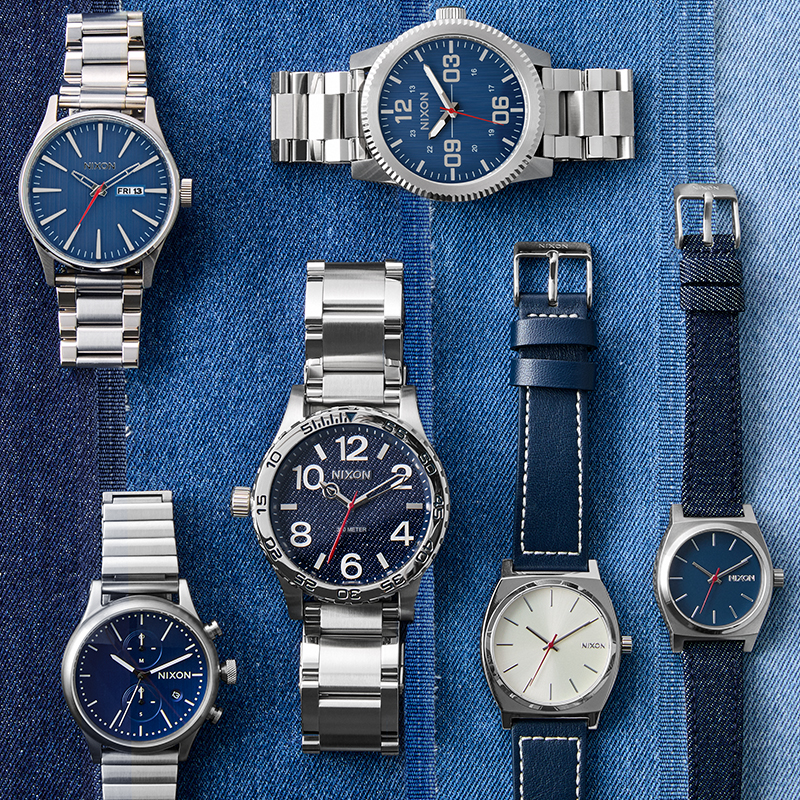 laydown image of all watches in the denim collection laying on top of different colored denim material.