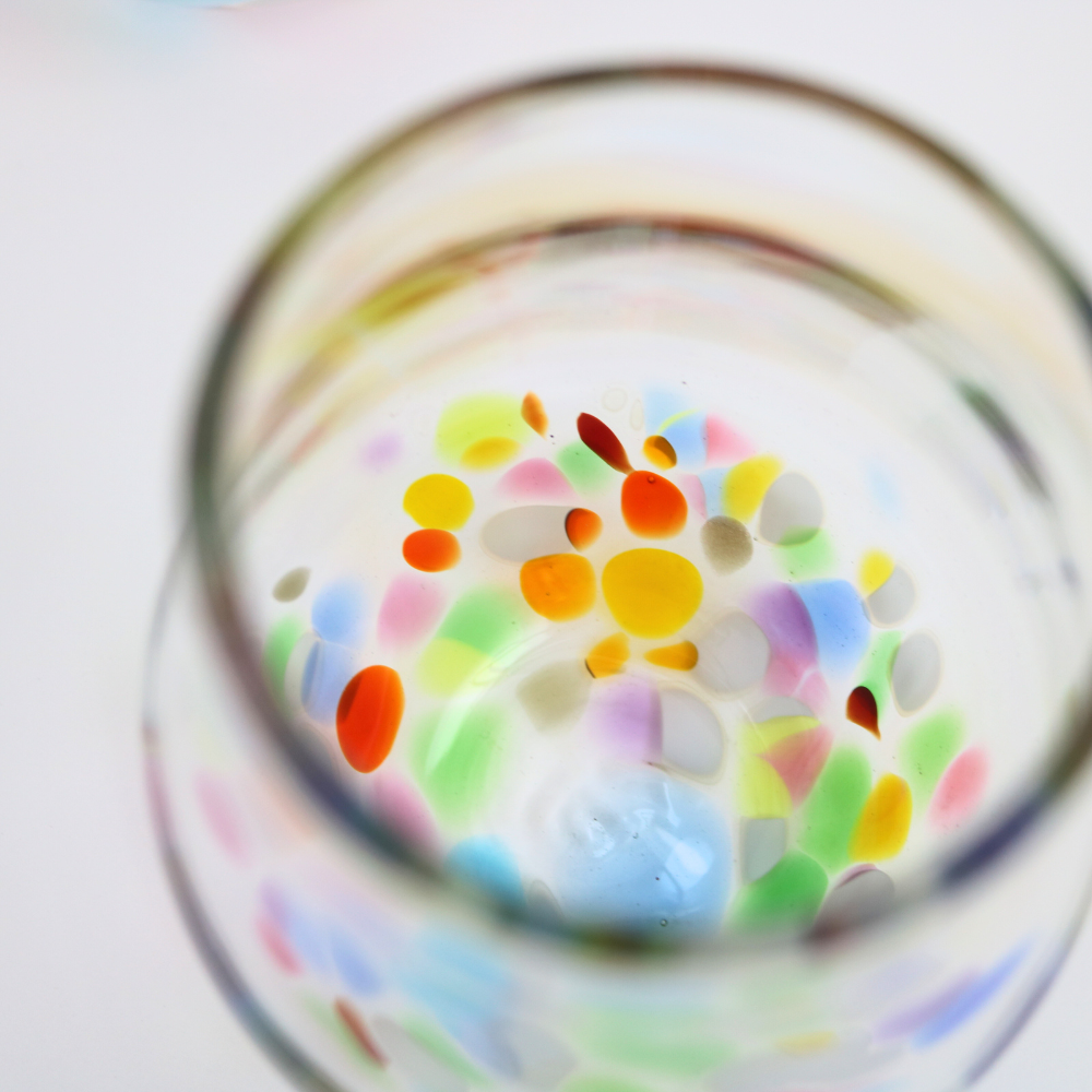 Top view of a stemless wineglass with a colourful bottom.