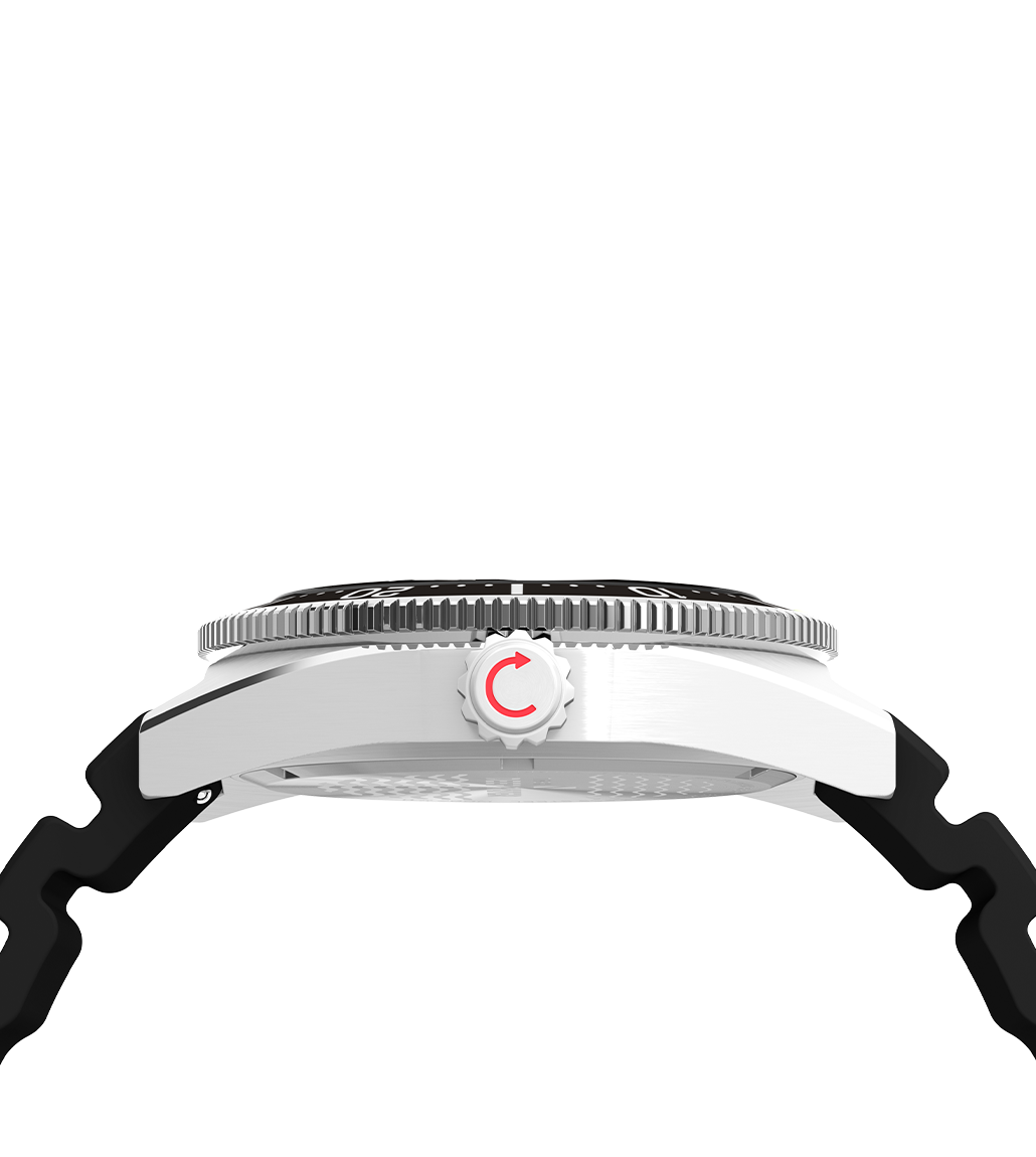 Side profile view of the Timex Deepwater Reef 200 GMT showing the stainless steel case, ridged rotating bezel, and a screw-down crown with a red arrow symbol.
