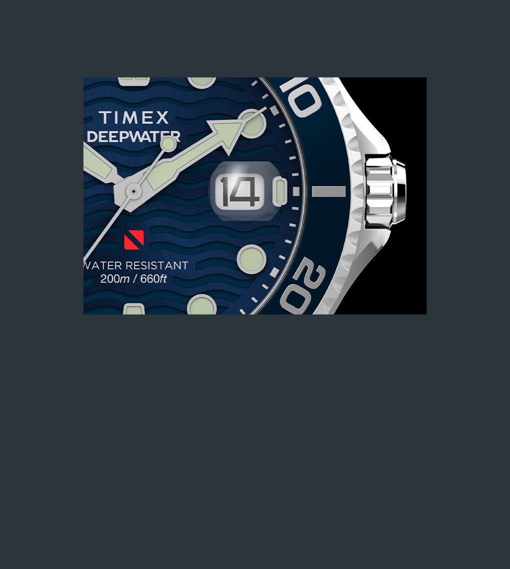 Close-up of the watch dial highlighting the magnified date window showing “14”, luminescent arrow-shaped hands, and the 