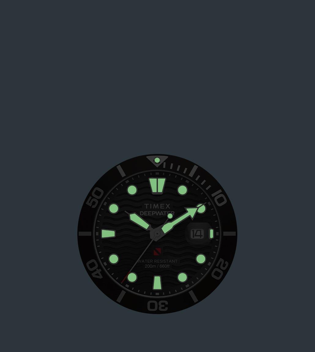 Glow-in-the-dark view of the Timex Deepwater watch, with illuminated hour markers, hands, and bezel marker glowing green against a dark background.