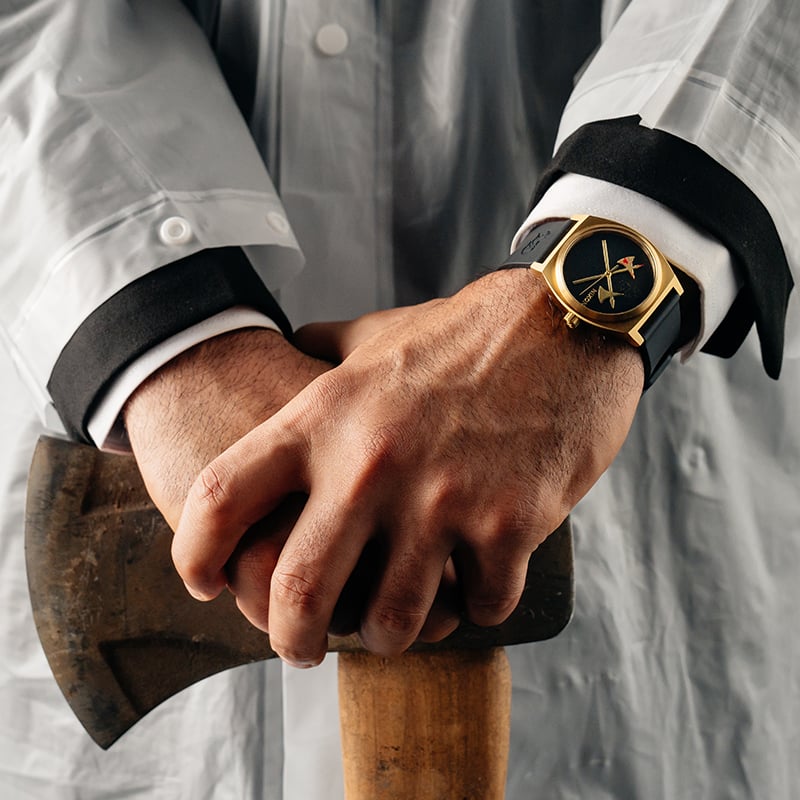 image of the Liquid Death IV watch being worn by a man holding an ax.