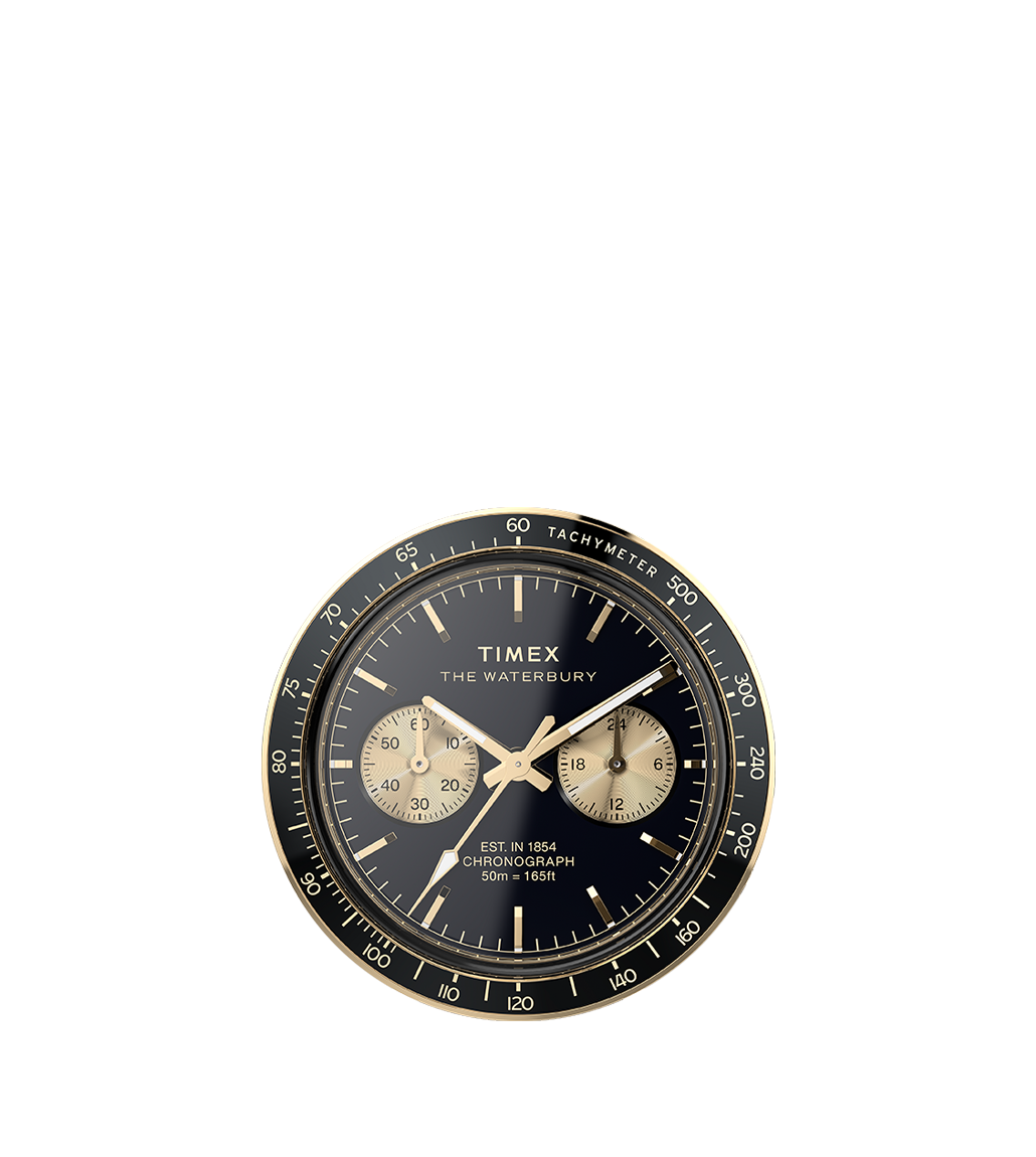 A detailed shot of the Timex Waterbury Heritage Chronograph dial, featuring a black background with gold-tone subdials and a tachymeter scale. The polished gold-tone hands and indices add a vintage-inspired sophistication to the timepiece.