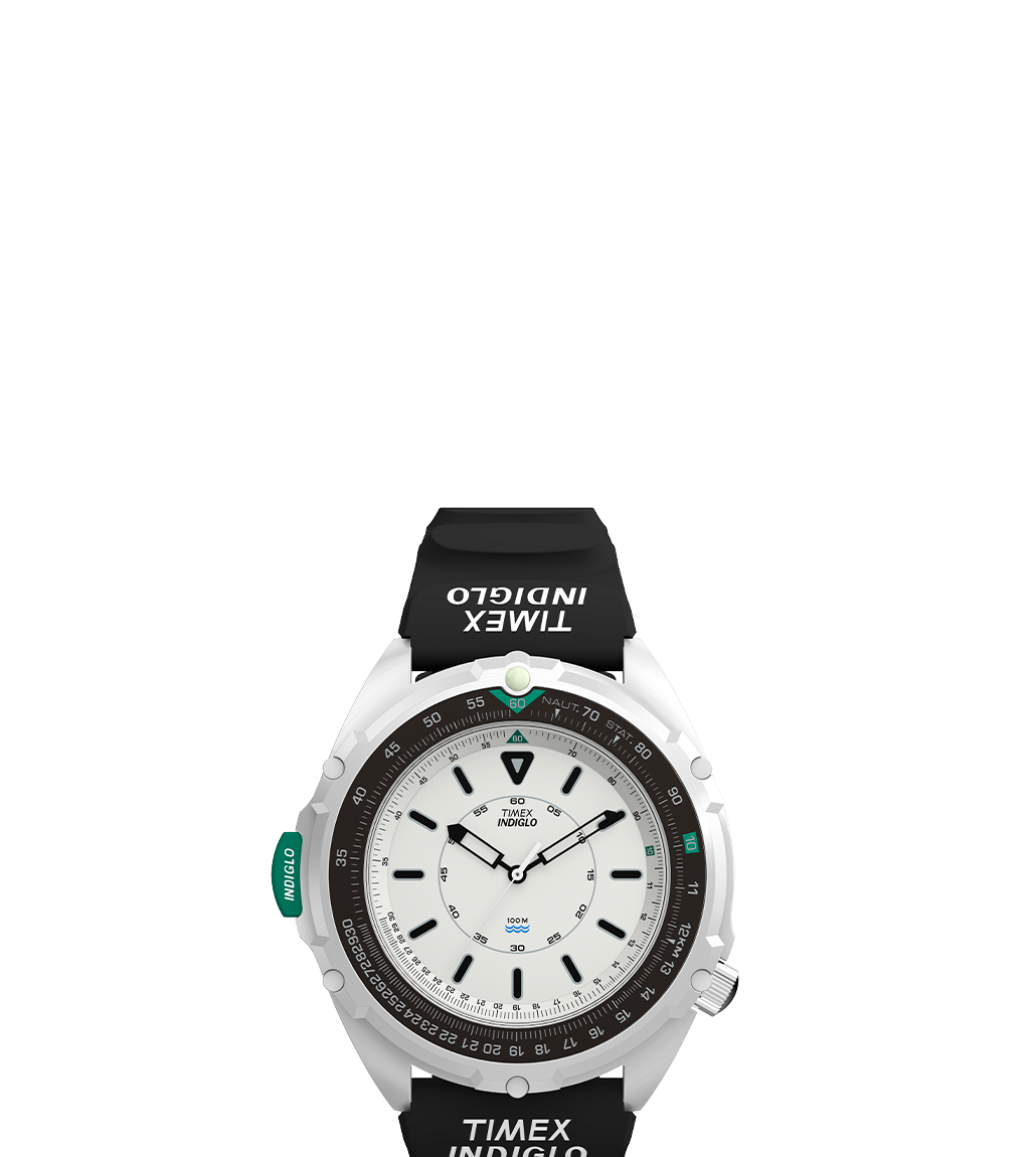 A full top-down view of the Timex 1995 Intrepid Reissue watch, featuring a white dial with bold black indices, a black rotating bezel, and a black rubber strap with 'TIMEX INDIGLO' branding. The teal INDIGLO button is prominently positioned on the left side of the case, accentuating the watch's functionality and rugged aesthetic.