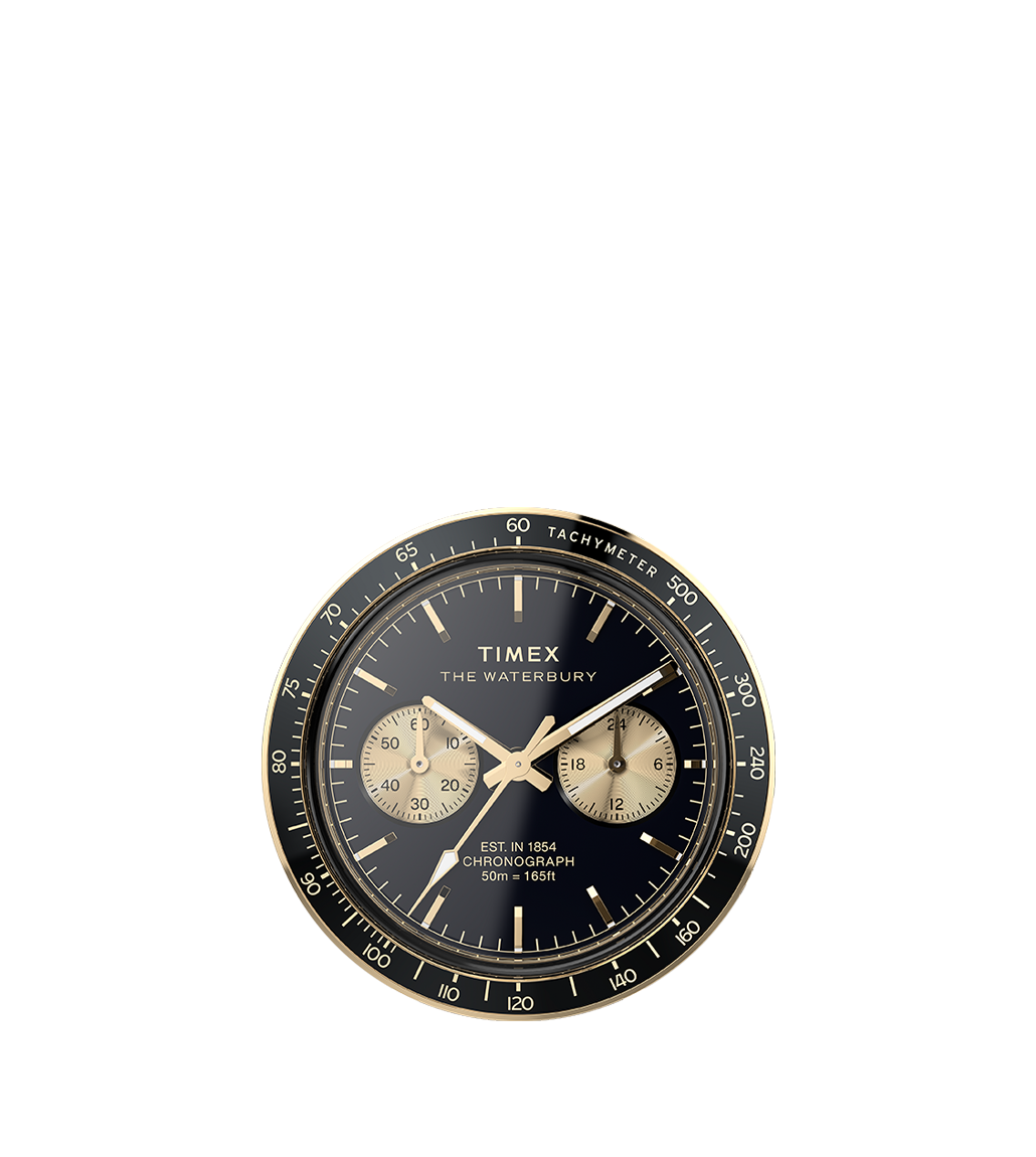 A detailed shot of the Timex Waterbury Heritage Chronograph dial, featuring a black background with gold-tone subdials and a tachymeter scale. The polished gold-tone hands and indices add a vintage-inspired sophistication to the timepiece.