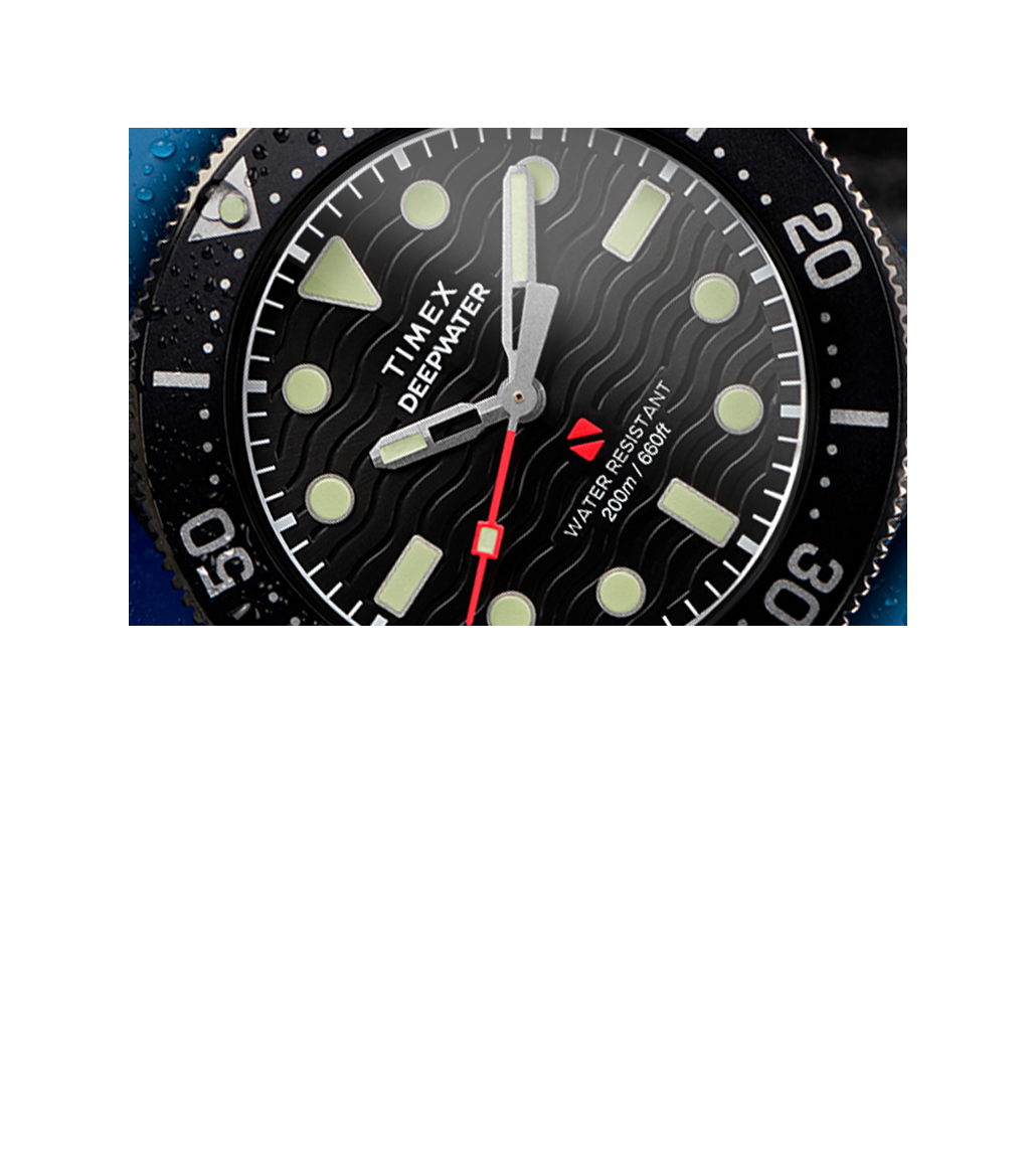 Macro image of the Timex Deepwater 200M dial and bezel, emphasizing the textured wave pattern on the dial, luminous rectangular markers, bold hour and minute hands, and the red seconds hand. Water droplets accentuate its dive-ready build and 200-meter water resistance rating.