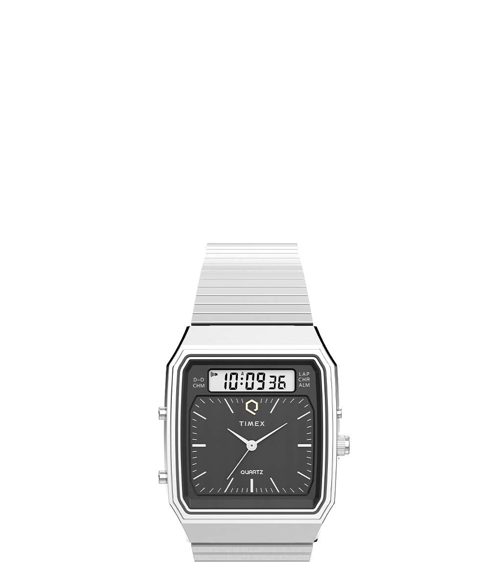 A Q Timex® 1982 Ana-Digi Reissue watch in a silver-tone finish with a black dial, showcasing its hybrid analog and digital display. The rectangular case design and sleek stainless steel bracelet highlight the vintage-inspired aesthetic.