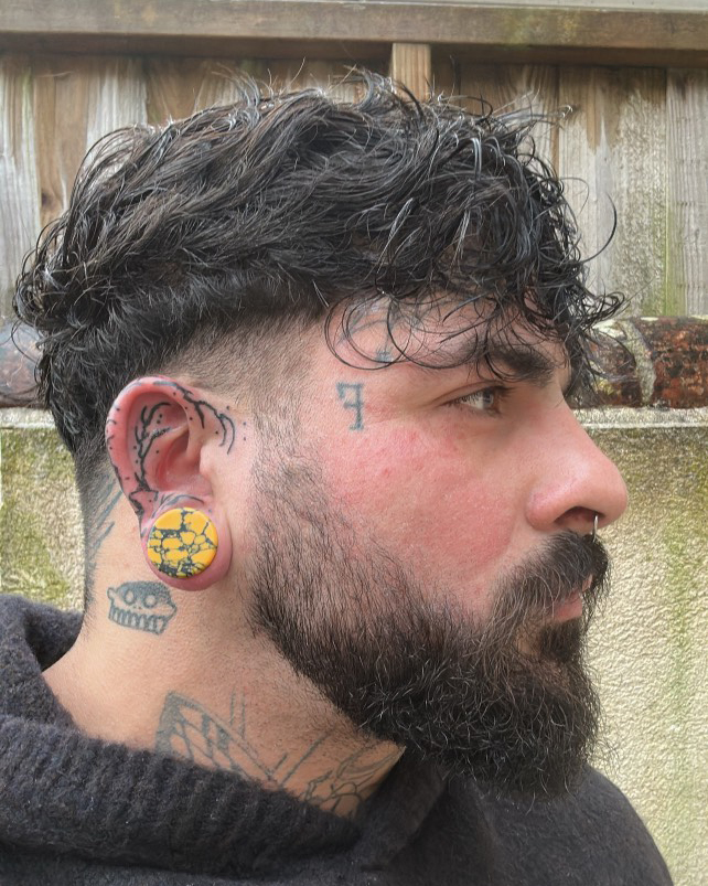 Girl wearing big Marble Black & Orange Stone Plug / Gauge