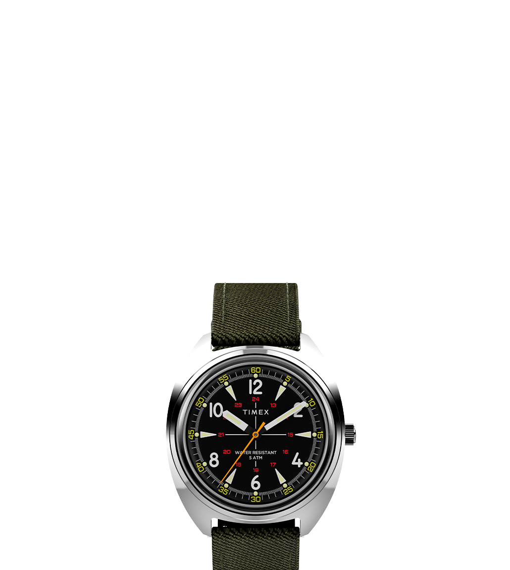 Front view of the Timex x Bespoke Post watch featuring a black dial with white Arabic numerals, yellow seconds hand, red 24-hour markers, and an olive green fabric strap against a white background.