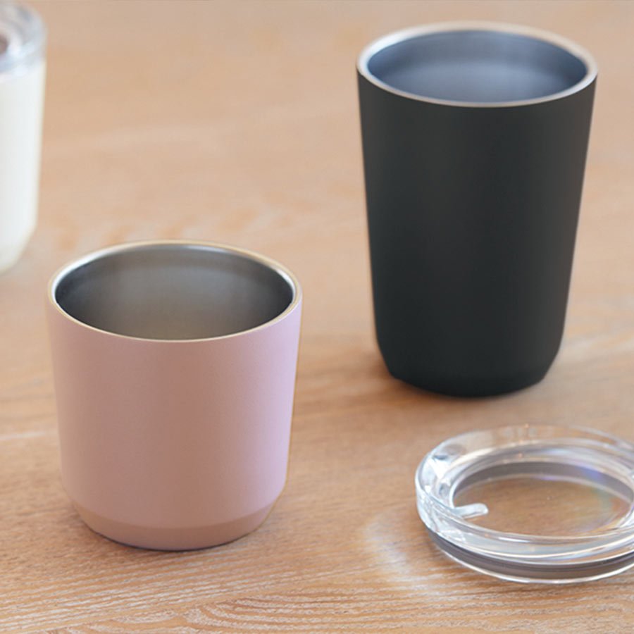  TO GO tumbler 240ml in pink and TO GO tumbler 360ml in black without the lids on a desk  