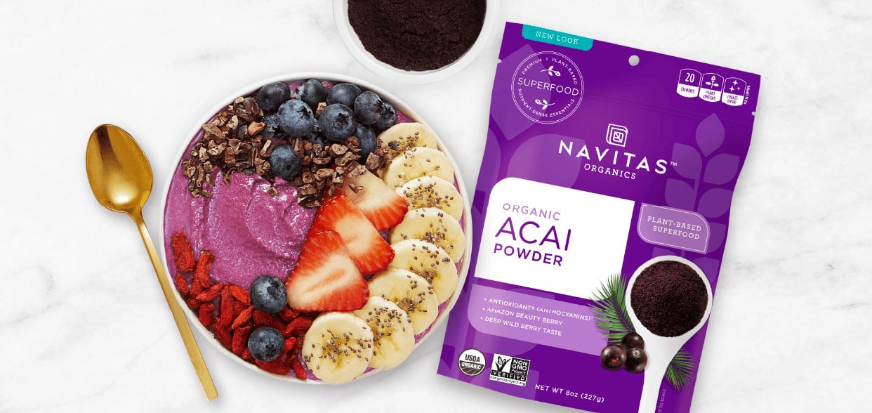 An Acai smoothie bowl next to a bag of Navitas Organics Acai powder