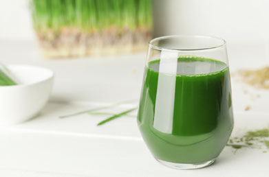 Glass of water mixed with Navitas Wheatgrass Powder