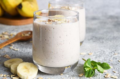 Smoothies made with Navitas Maca Powder surrounded by fresh ingredients