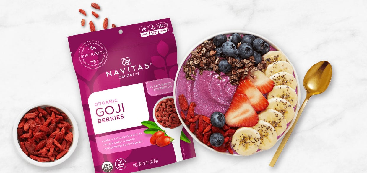Package of Navitas Goji Berries next to bowl of yogurt topped with fresh ingredients