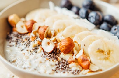 Closeup bowl of oatmeal topped with Navitas Chia Seeds and fresh fruit