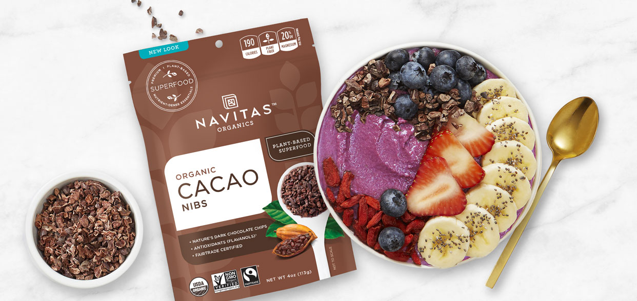 Fruit and yogurt bowl made with Navitas Cacao Nibs next to package of Navitas Cacao Nibs 