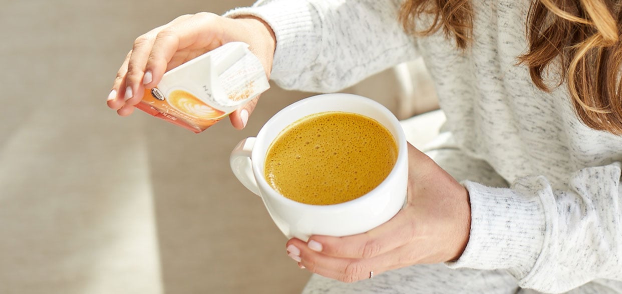 Mug of golden milk latte made with Navtias Turmeric Latte mix
