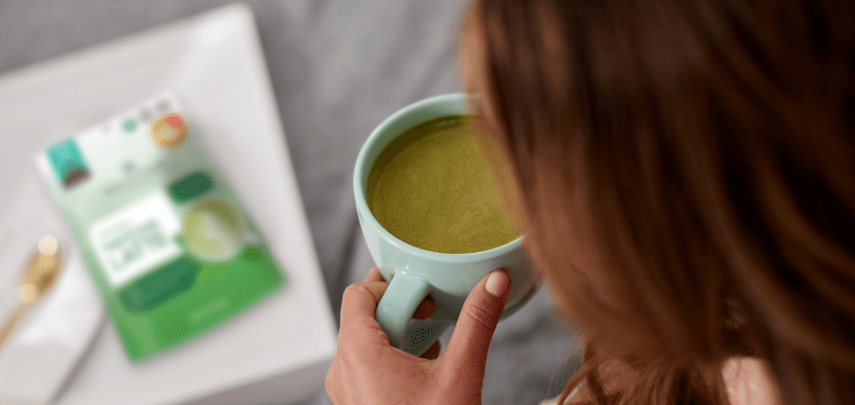 A woman sipping on a Navitas Organics Matcha Latte