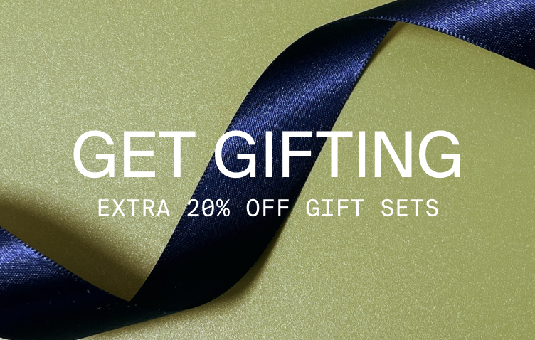 Image of a blue ribbon on a green background. Get gifting. Extra 20% off gift sets.