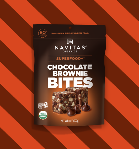 A package of Navitas Organics Superfood+ Chocolate Brownie BITES on a two-toned brown striped background.
