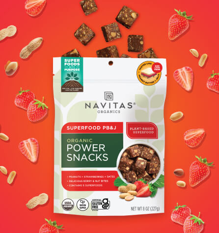 A package of Navitas Organics Superfood PB&J Power Snacks against an orange background surrounded by peanuts and strawberries.