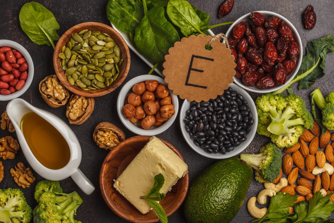 Foods rich in vitamin E including nuts, seeds, avocado, and greens

