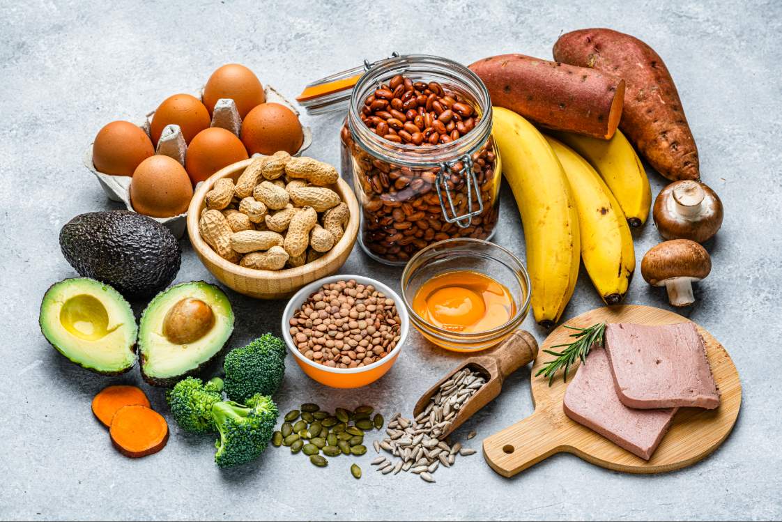 Assortment of foods containing biotin including eggs, bananas, nuts, vegetables, and seeds
