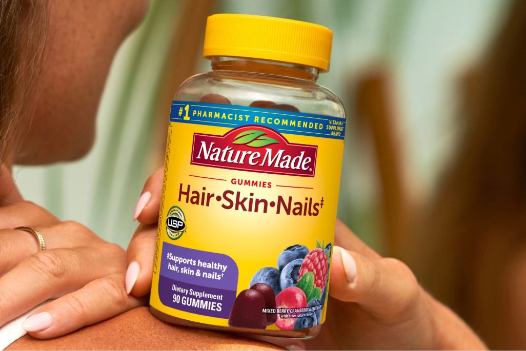 Hand holding Nature Made Hair Skin and Nails gummies bottle
