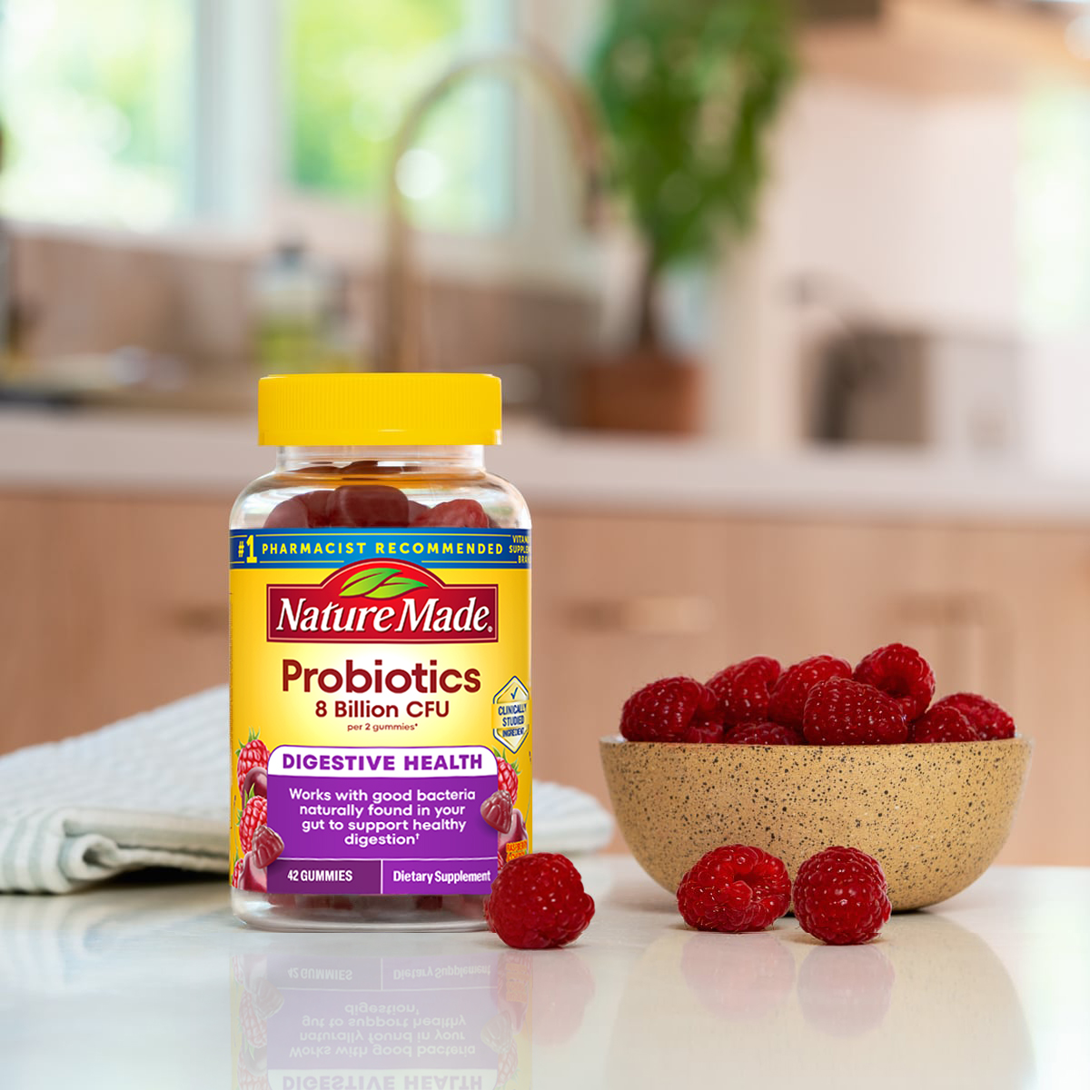 Nature Made Probiotics Extra Strength 8 Billion CFU bottle next to a bowl of berries on a kitchen counter.