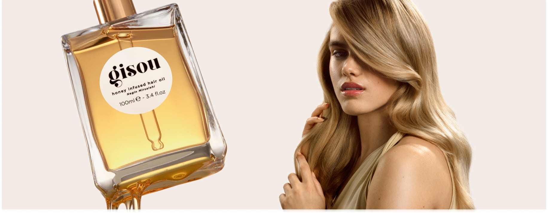 model with long hair with a bottle of the honey infused hair oil