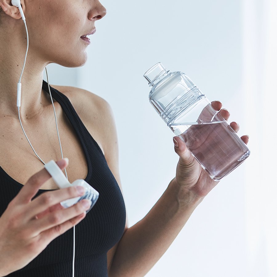  WORKOUT bottle clear being used by a person in exercise apparel  