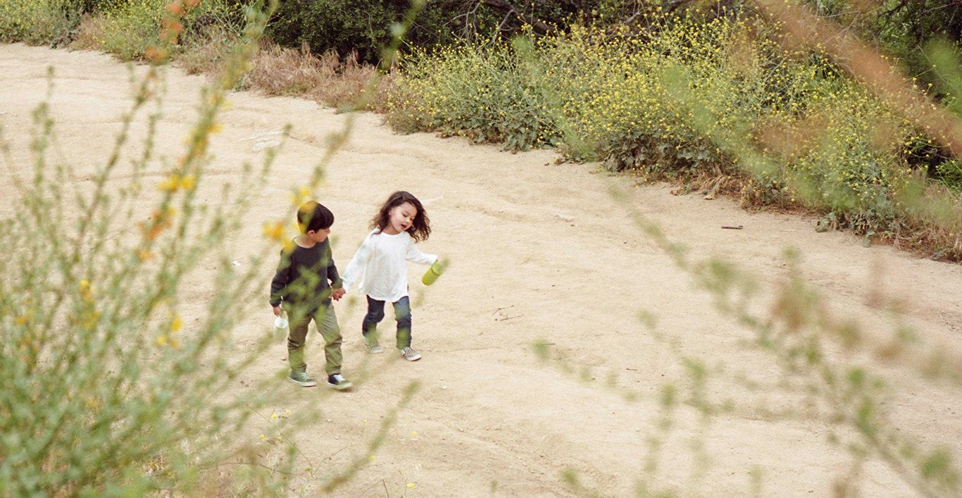  Two children walking up a dirt road  