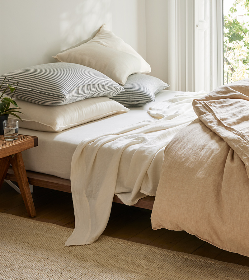Cozy bed styled with our latest Summer Linen sheet collection in Khaki Chambray, Cream, and Charcoal Chambray and White Stripe.