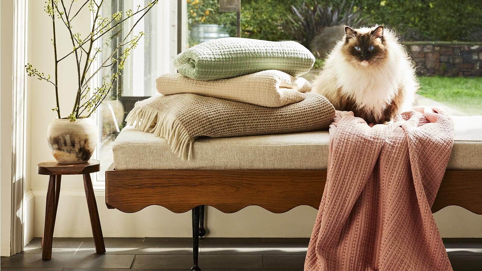 Brooklinen Lightweight Throw Blankets on a Bench with a Cat