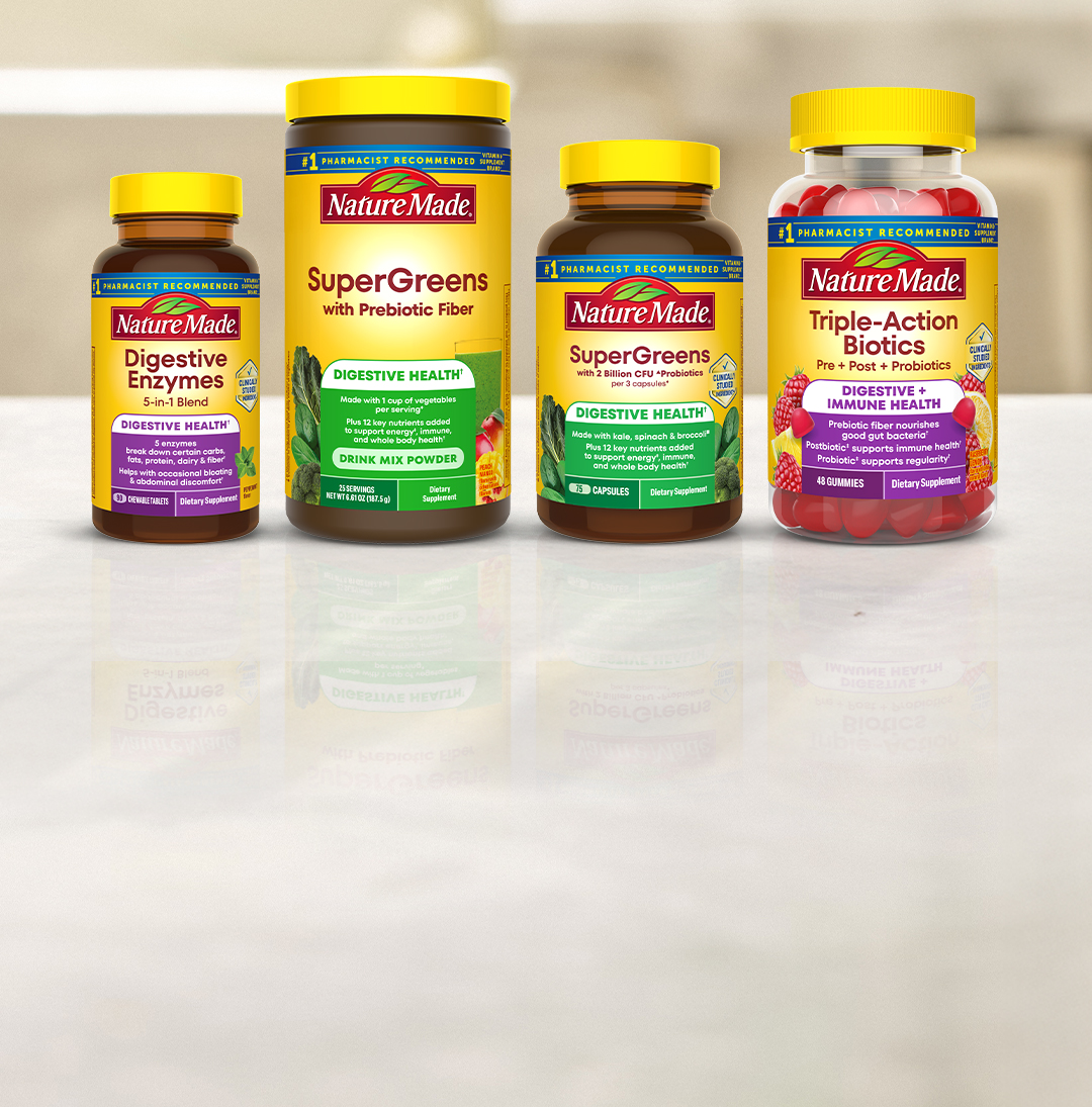 Nature Made digestive health supplements including SuperGreens, Digestive Enzymes, and Triple‑Action probiotics on a countertop.