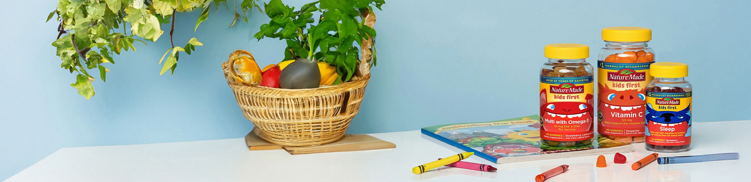 Nature Made Kids First gummy vitamins with crayons and activity book on a table.