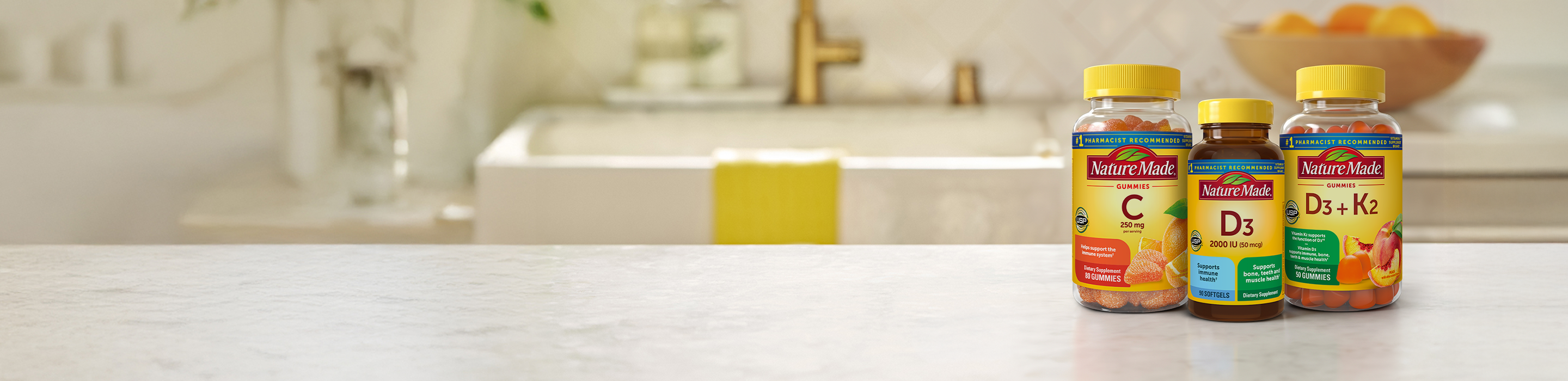 Nature Made Vitamin C gummies, D3 softgels & D3 + K2 gummies on a kitchen counter