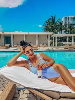 Woman holding tanner by the pool