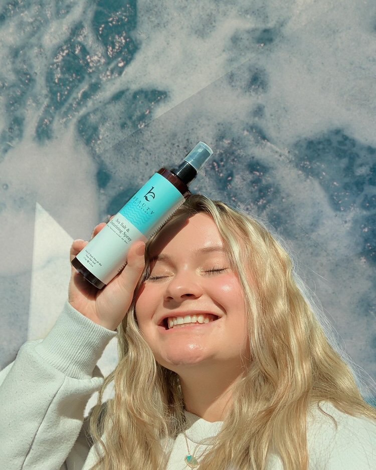 Woman using Beauty By Earth sea salt spray 