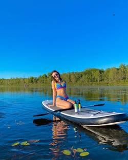 Woman paddle boarding with Beauty By Earth Sunscreen