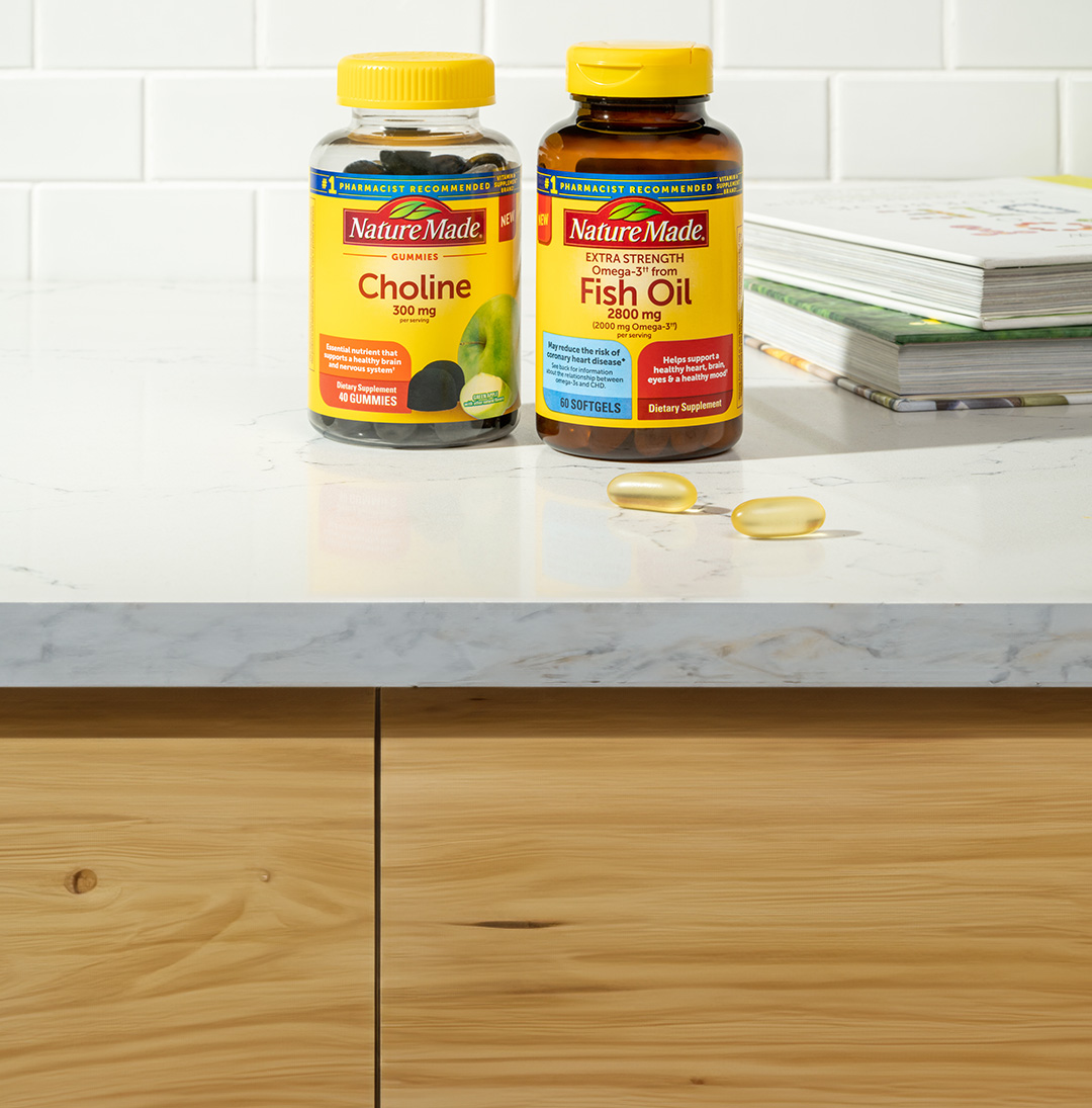 Nature Made® Choline Gummies and Fish Oil Softgels sitting on a counter