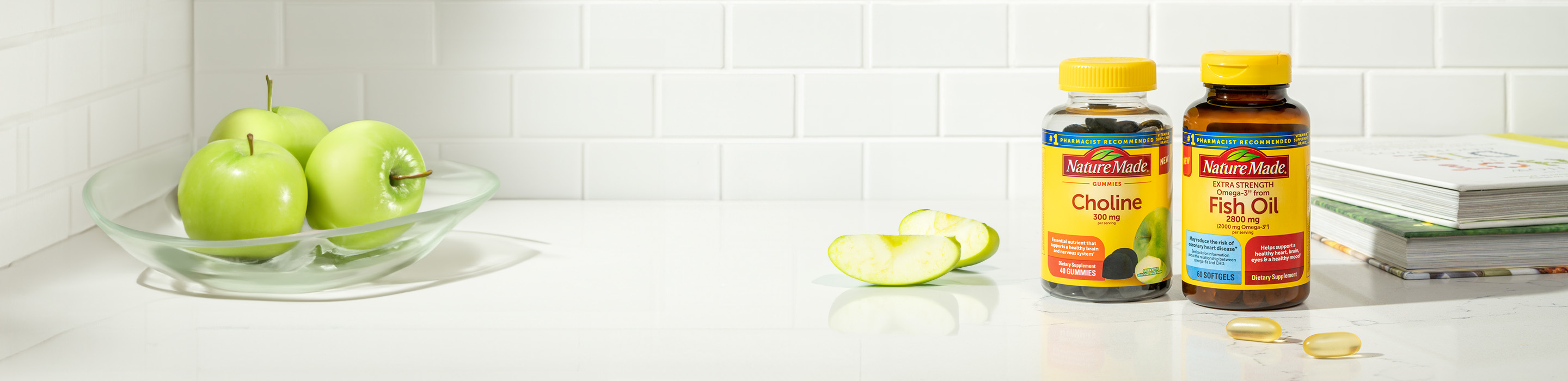 Nature Made® Choline Gummies and Fish Oil Softgels sitting on a counter