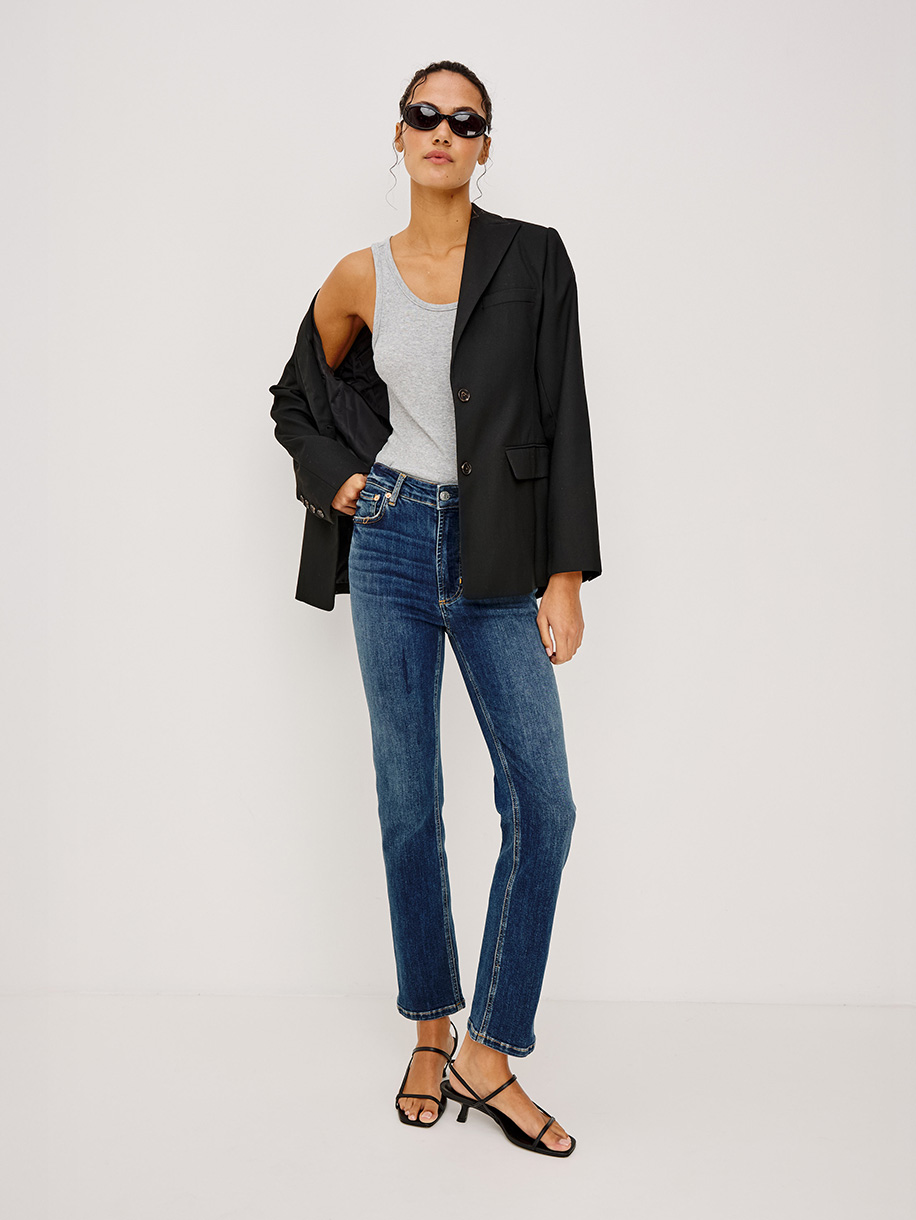 Woman in slim fit jeans on white background. Click here to shop Slim Fit Jeans