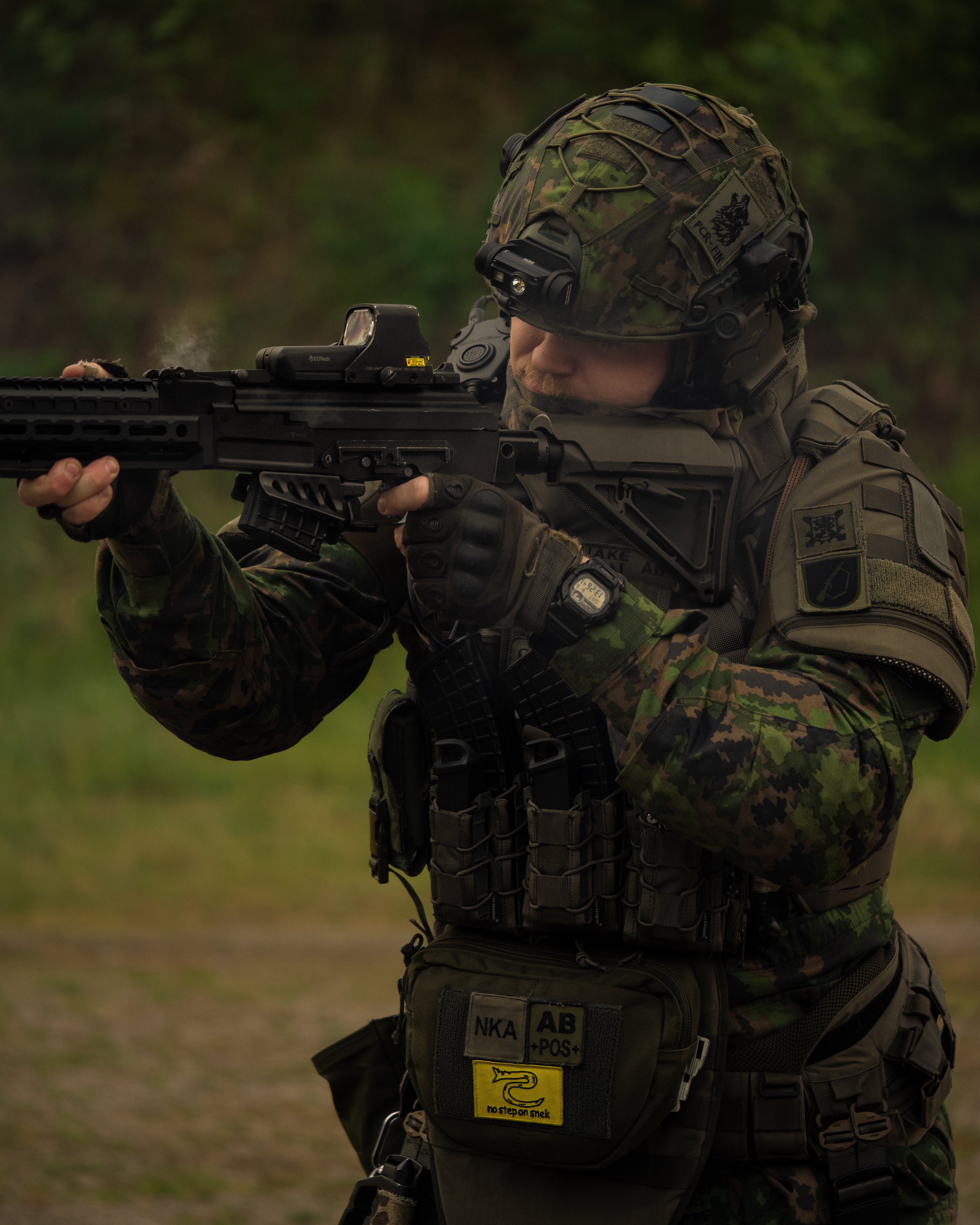 Man with a rifle ak-47 in hand on a gun range shooting. He is wearing body armor, a ballistic helmet , gloves and earpro. Finnish reservist.