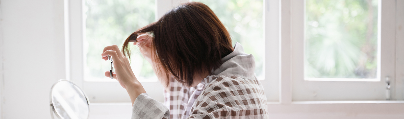 Woman at home giving herself a haircut