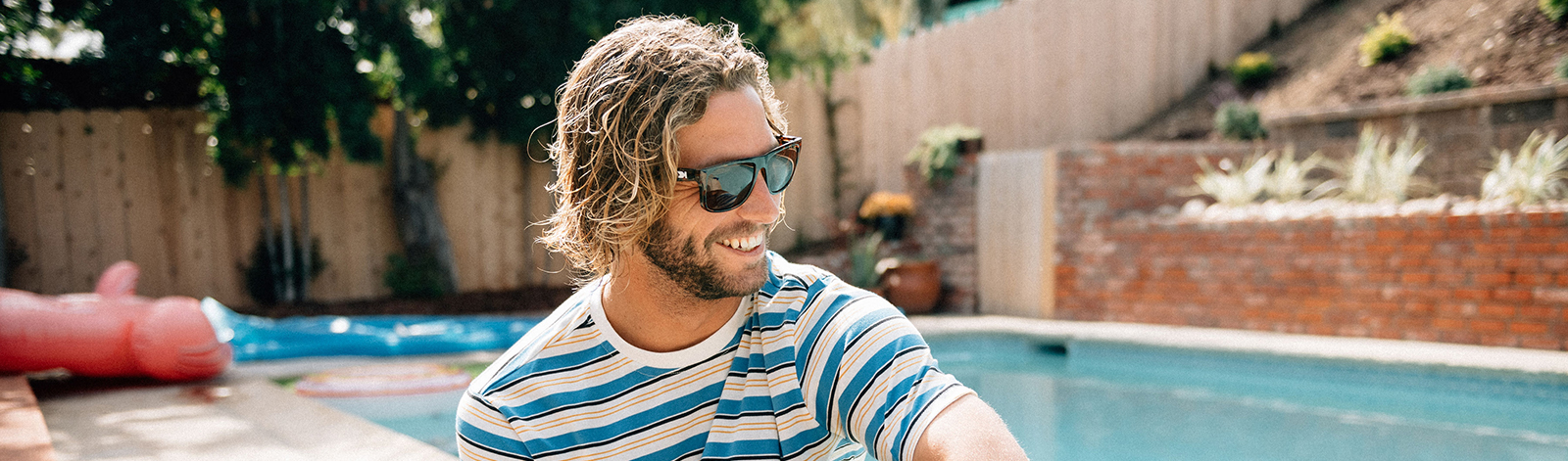 Man wearing Knockaround Torrey Pines sunglasses by the pool