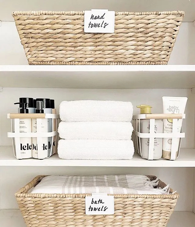 Organized shelves with storage baskets holding towels and other bathroom products