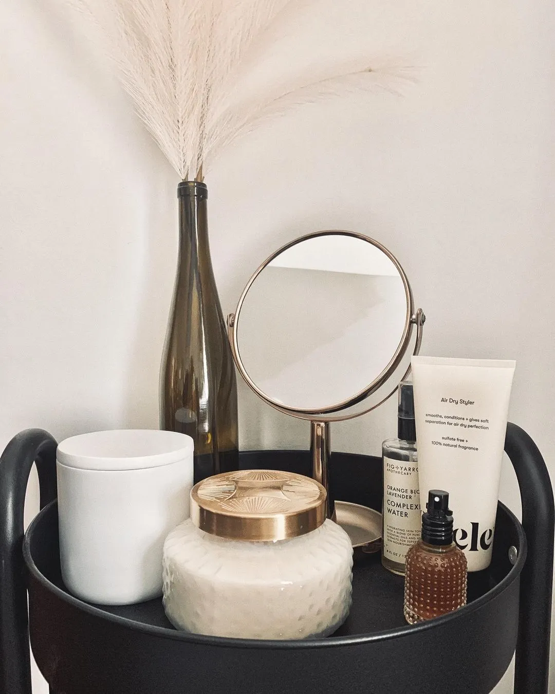 Odele Air Dry Styler on a nightstand with candles, plants and a mirror